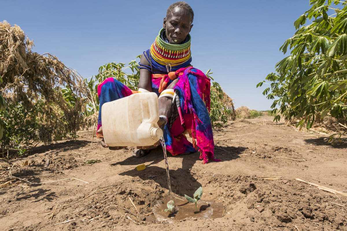 A woman with a water canister on her field