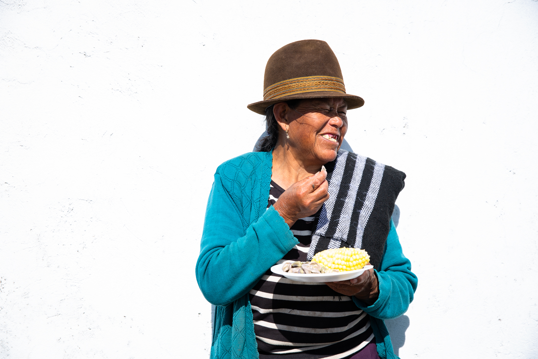 Ernährung Ecuador Eine Frau die glücklich Mais isst.