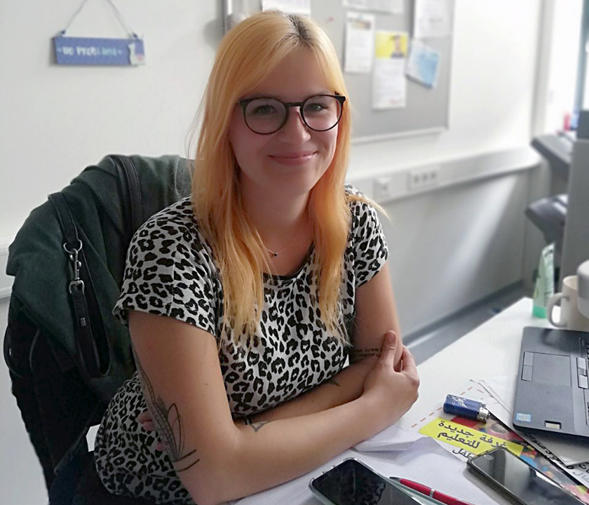 Neue Mitarbeiterin Lucca Böttger sitzt im Haus der Begegnung am Schreibtisch