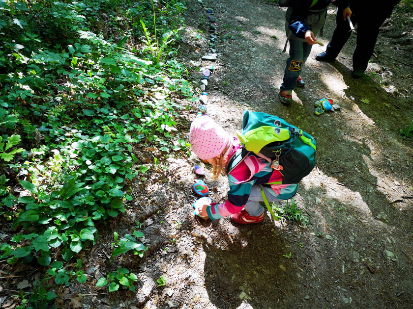 Kita-Kinder legen die farbenfroh bemalten Steine in den Sultmer Walt an das Ende der meterlangen Steinschlage.