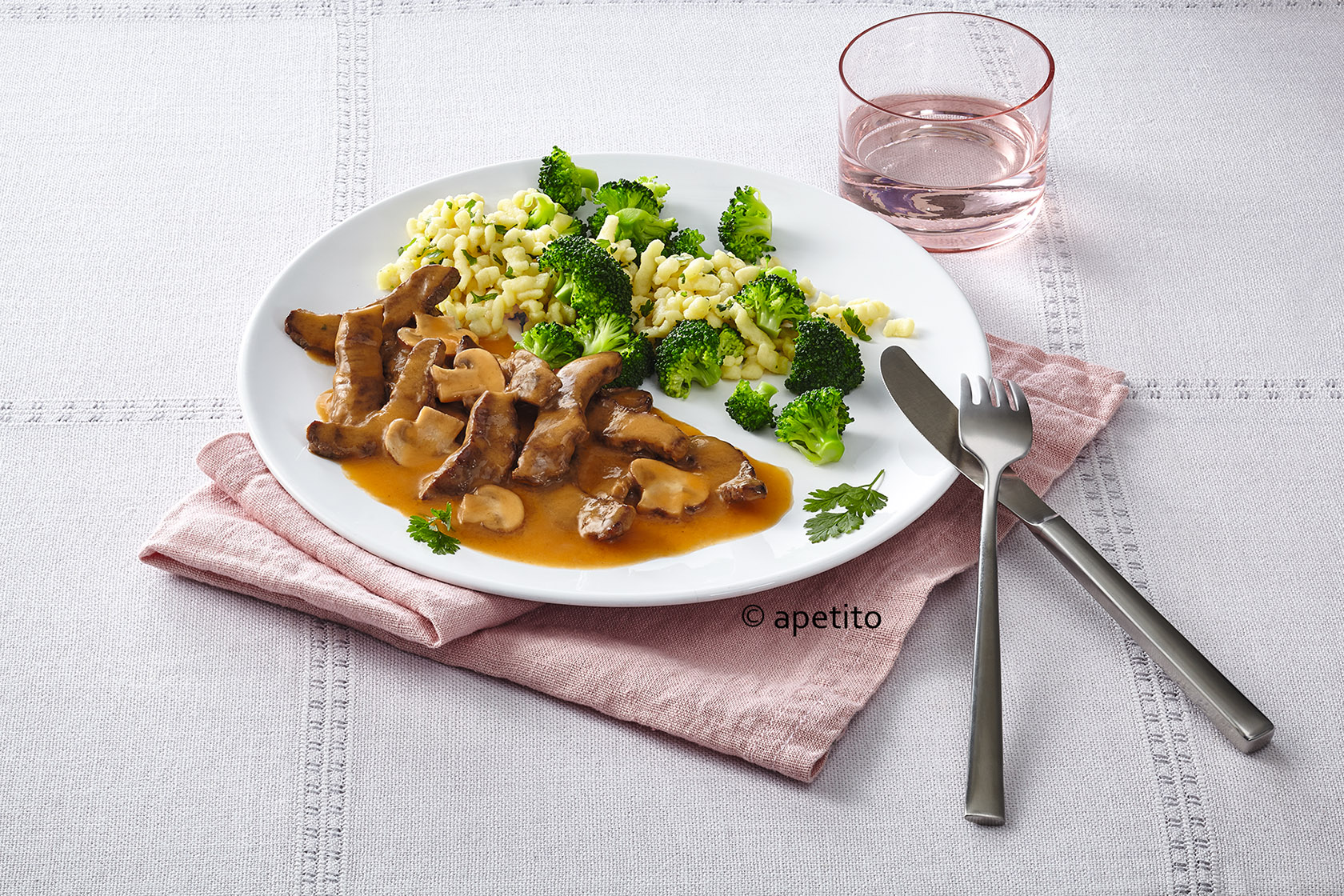 Menüservice Auf einem weißen Porzellanteller angerichtetes Essen