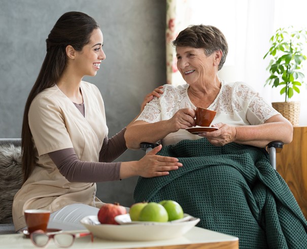Gespräch mit Kaffee von Bewohnerin und Pflegerin 