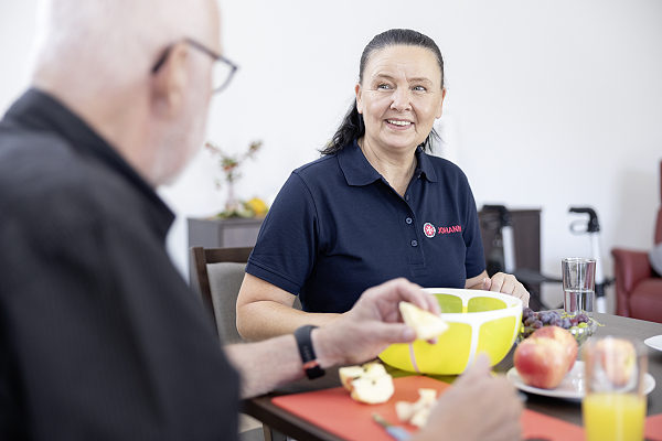 Eine Pflegerin der Johanniter bereitet mit einem tagesgast das Frühstück vor