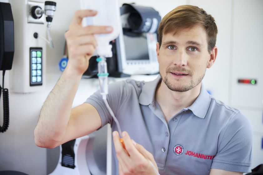 Johanniter-Rettungssanitäter bereitet im Einsatzwagen eine Infusion vor.