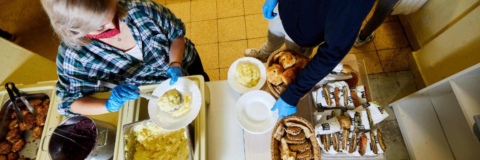Ehrenamtliche geben Essen für Bedürftige bei der Kiezmahlzeit aus.