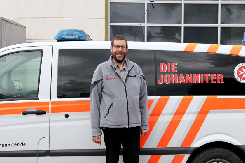 Ole Hesprich vor einem Johanniter-Einsatzfahrzeug