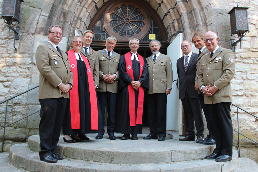 Johanniter-Vorstände, Dienststellenleiter sowie Pfarrerinnen und Pfarrer vor dem Eingang der Göttinger Sankt-Albani-Kirche.
