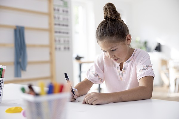Ein Mädchen macht ergotherapeutische Schreibübungen.