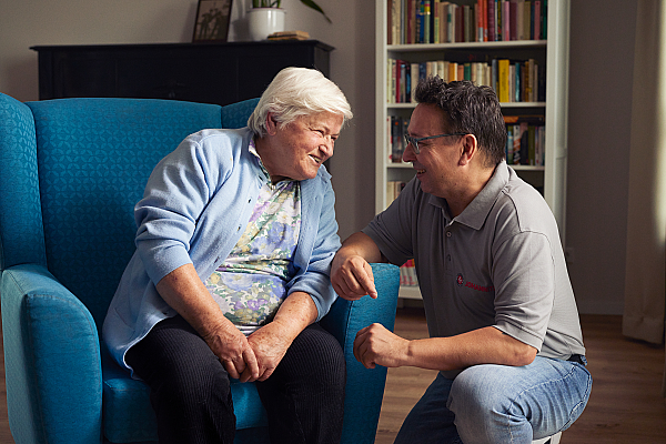 Ein Gespräch zwischen einer Seniorin und einem Pfleger der Johanniter.