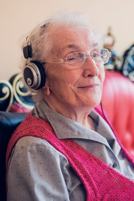 Seniorin hört mit Kopfhörern Märchen im Mutter Eva von Tiele Winckler-Pflegeheim in Wentorf.