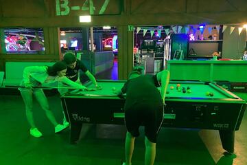 Mehrere junge Leute spielen Billard