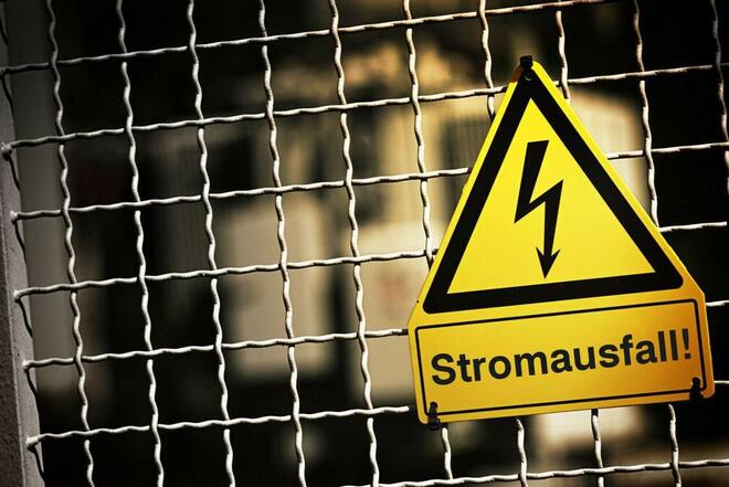 Ein gelbes Warnschild mit der Aufschrift "Stromausfall".