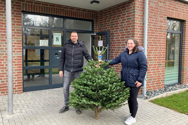 Eine Frau und ein Mann mit einem Tannenbaum