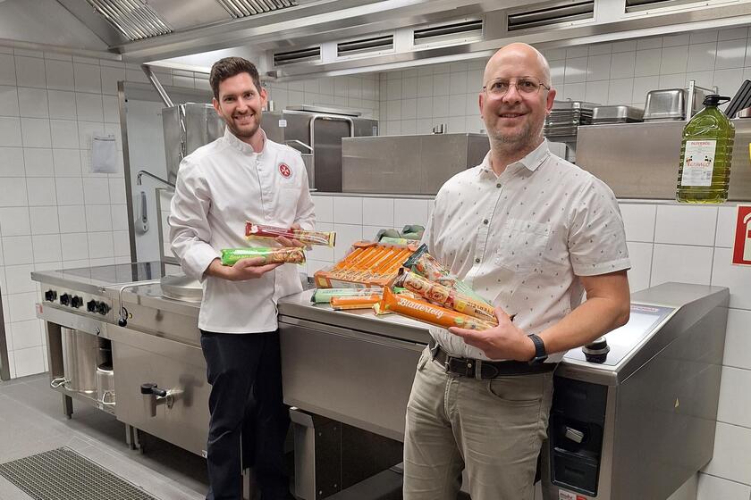 Küchenleitung Johannes Lorenz und Matthias Boßle halten die Teige in Händen