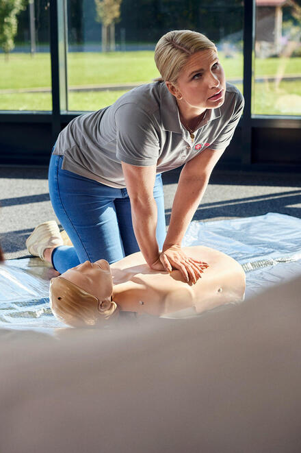 Eine Erste-Hilfe-Trainerin der Johanniter zeigt die Herzdruckmassage.