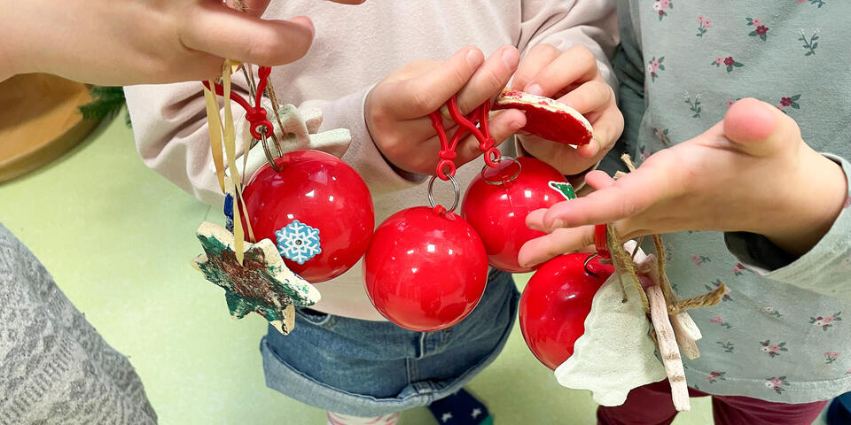 Kinder halten Weihnachtsschmuck in ihren Händen