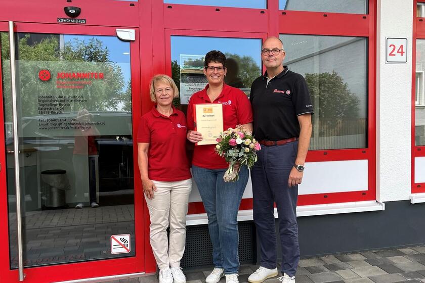 drei Personen, zwei Frauen und ein Mann, vor dem Eingang der Tagespflege Buseck