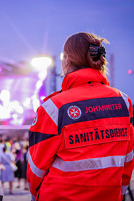 Eine Johanniterin engagiert sich ehrenamtlich im Sanitätsdienst auf einem Konzert. 