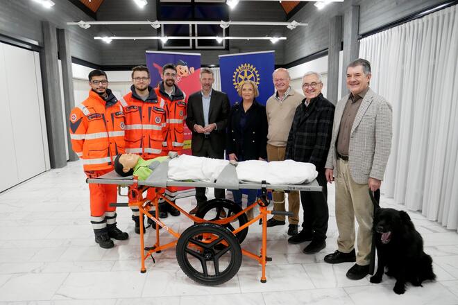 Vertreter der Johanniter Ladenburg und des Rotary Clubs stehen hinter der Feldtrage und lächeln in die Kamera.