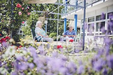 Zwei Bewohnerinnen sitzen im Garten des Johanniter-Pflegewohnhaus Haus Kielwein