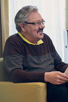 Ein älterer Herr wirf einen Blick in die Tageszeitung