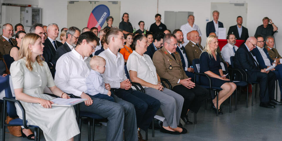 Prof. Dr. Simon Little sitzt mit seiner Familie in der Ersten Reihe bei der Laudatio.