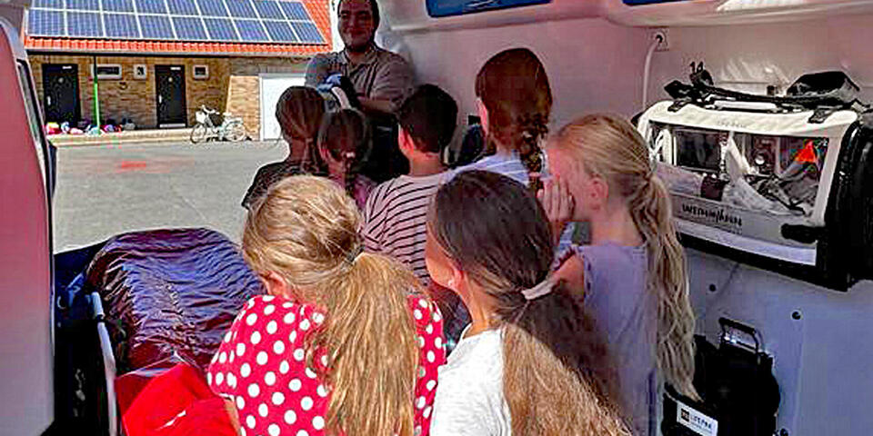 Kinder in einem Rettungswagen mit einem Johanniter