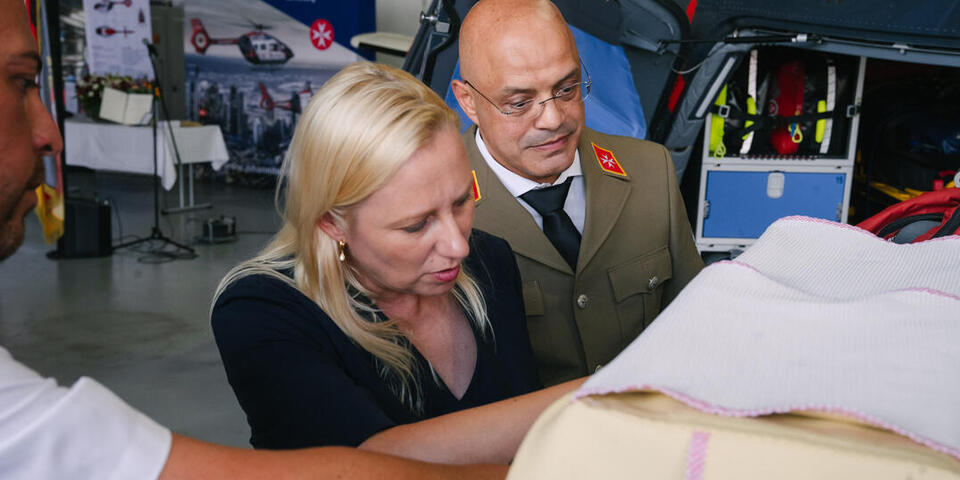 Die Hessische Ministerin für Familie, Senioren, Sport, Gesundheit und Pflege bekommt von Mumi Taleb, dem Ärztlichen Leiter JLR, die Ausstattung eines Hubschraubers gezeigt.