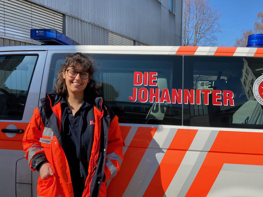 Junges Mädchen in Einsatzkleidung vor einem Einsatzfahrzeug