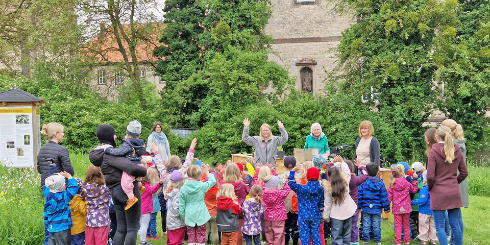 Zahlreiche Kinder und ein paar Erwachsene in einem Park