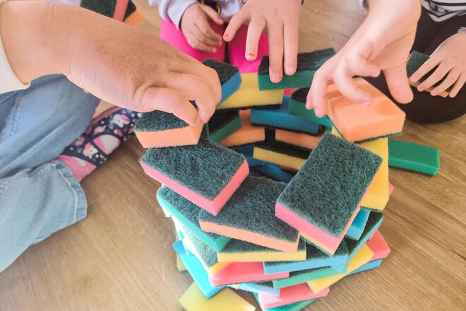 Kinderhände spielen mit Haushaltsschwämmen