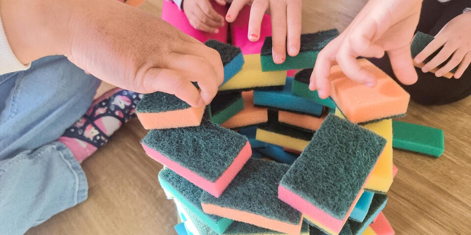 Kinderhände spielen mit Haushaltsschwämmen