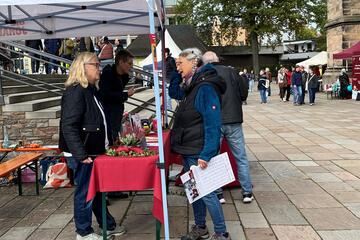 Besucher am Johanniterstand des Sozialmarktes Marburg