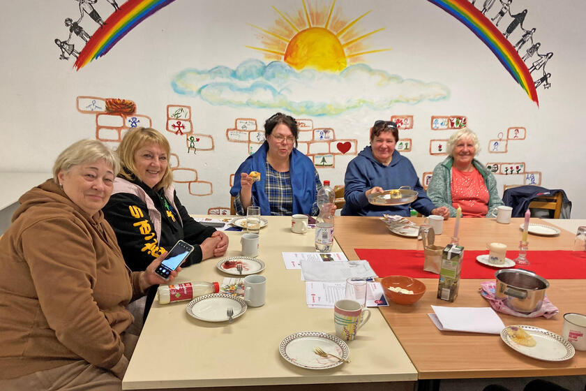 Frauen sitzen um einen Tisch und essen gemeinsam