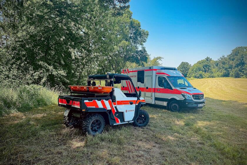 Ein allradgetriebenes Geländefahrzeug und eine Rettungswagen auf einer Wiese
