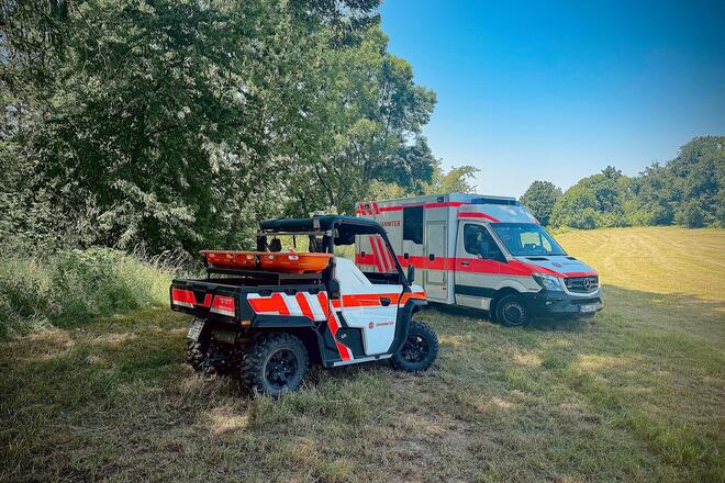 Ein allradgetriebenes Geländefahrzeug und eine Rettungswagen auf einer Wiese