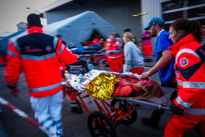 Notfallübung: Sanitäter bringen Patientin im Freien schnell zum Behandlungszelt