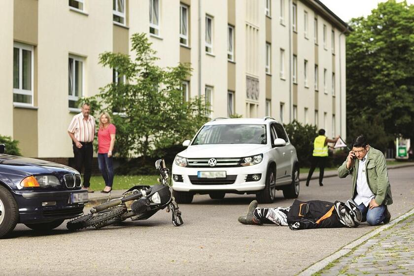 Szene Unfall Auto und Motorrad auf Straße in Wohngebiet