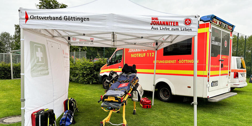 Ein Rettungswagen und ein Johanniter-Pavillon auf einer Wiese