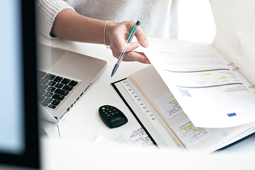 Eine Frau blättert in einem Ordner.