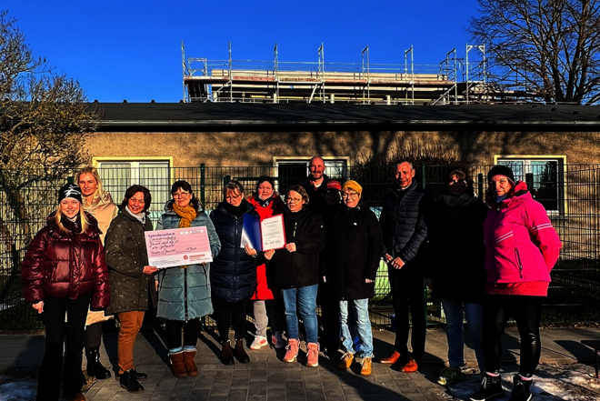 Gruppenbild des Teams der Kita Niemegk vor der Einrichtung mit Regionalvorstand Ralf Boost und Kitaleitung Ines Maager