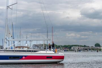 Das Segelboot kehrt in den Hafen von Travemünde zurück. An Bord sind zwei Personen zu sehen.