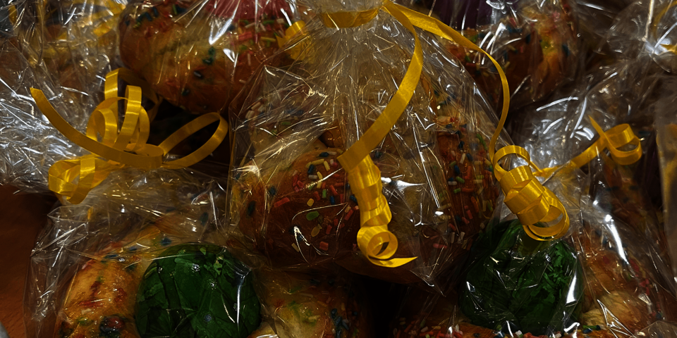 Rundes Hefegebäck in dem jeweils ein buntes Ei steckt, ist in Plastikfolie verpackt.