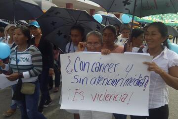 Eine Demonstration, auf dem Plakat steht „Krebs und keine medizinische Behandlung? Das ist Gewalt!"