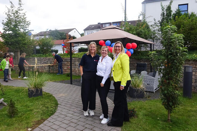 Drei Frauen in einem Garten.
