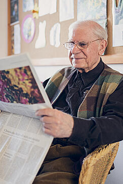Ein älterer Herr liest in der Tageszeitung