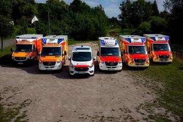 Fünf Einsatzfahrzeuge stehen im Halbkreis, es ist Tag