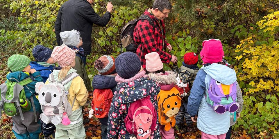 Zwei Männer und Kinder im Wald. 