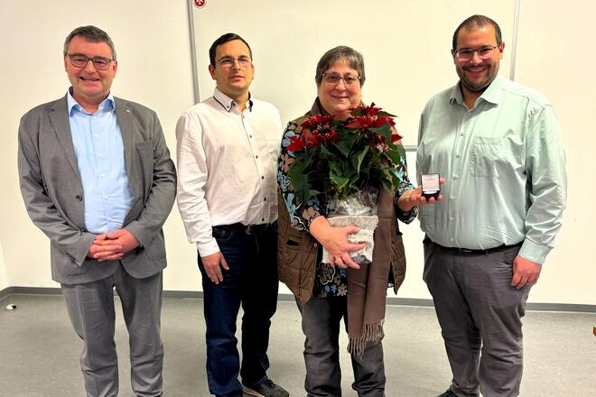 Christine Zeitler (langjährige Mitarbeiterin der Johanniter) erhält zur Verabschiedung einen Blumenstrauß und eine Gedenkmünze.