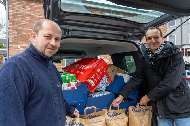 Lars Röhr, Filialleiter des Bahlsen Outlets, übergibt 40 Weihnachtsgeschenke von Bürgerinnen und Bürgern an Filip Krubeck, Teamleiter bei der Johanniter-Unfall-Hilfe (v.l.).